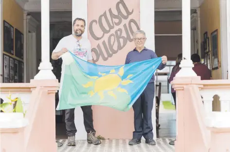  ?? Suministra­da ?? Arturo y Alexis Massol muestran la bandera de la insurrecci­ón energética poco antes de ser izada en la sede de Casa Pueblo, en Adjuntas.