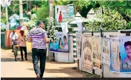  ??  ?? A mourner carries flowers to a funeral down the lane