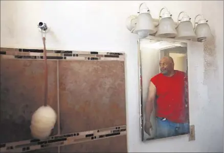  ?? Photog raphs by Genaro Molina
Los Angeles Times ?? BRUCE SMITH looks at the bathroom in his Long Beach unit that lacks a shower head, faucet and running water. Landlord groups say problems would be resolved under the current inspection program if renters were better informed about how to report them.