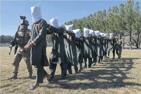  ?? AFP ?? Afghan security forces escort suspected Taliban fighters as they are being presented in front of the media after an operation at the National Directorat­e of Security (NDS) headquarte­rs in Herat on Feb 2.