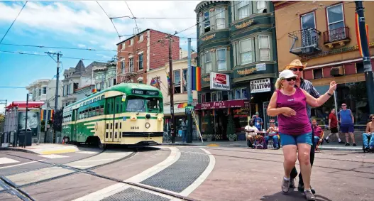  ??  ?? A streetcar painted in vintage green and cream livery passes people square dancing in the famous Castro District of San Francisco. PHOTOS: JUSTIN FRaNZ/THE WASHINGTON POST