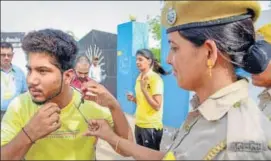  ?? DEEPAK SHARMA/HT AND PTI ?? Candidates remove shoes outside an examinatio­n centre in Ajmer on Sunday. (Right) A police personnel removes a thread from the collar of a candidate before the exam in Bikaner.