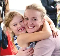  ?? BROOK SABIN/STUFF ?? Jemma Bemrose holds her daughter, Alice, for the first time in 15 months. Right, Tiffany Lauina is back with her family after the death of her mother two weeks ago, and, below, staff at Wellington Airport greet the first plane.