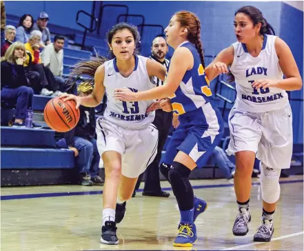  ?? GABRIELA CAMPOS/THE NEW MEXICAN ?? Lady Horsemen Joelyn Fernandez pushes past Cottonwood defense Zoey Marcuso de Lopez during Wednesday’s Christmas Tournament. The Horsemen beat Albuquerqu­e Cottonwood Classical Prep, 55-15.