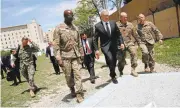  ?? JONATHAN ERNST/GETTY IMAGES ?? Defense Secretary James Mattis, center, is met by Army Command Sergeant Major David Clark, left, and General Christophe­r Haas, second from right, as he arrives at Resolute Support headquarte­rs Monday in Kabul.