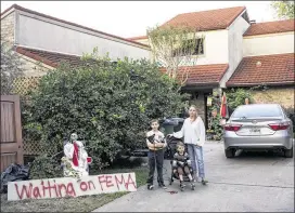  ?? SCOTT DALTON / NEW YORK TIMES ?? Rachel Roberts with her two sons, Troy, 10, and Harrison, 2, at their house in Houston on Oct. 12. Roberts put up the skeleton lawn decoration after waiting three weeks for FEMA to send someone to look at her flood-damaged home.