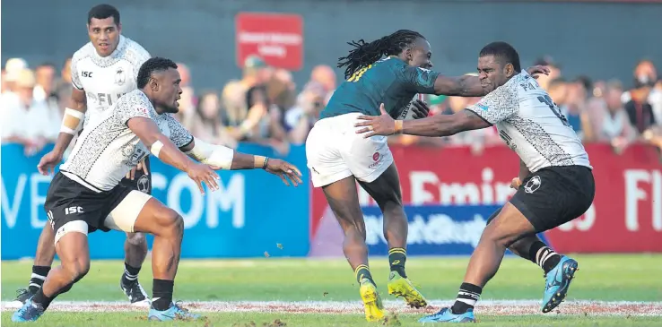  ?? Photo: Ian Muir ?? Fiji Airways Fijian 7s utility back Amenoni Nasilasila (left) misses a tackle on Branco Du Preez of South Africa as Vatemo Ravouvou makes an attempt while John Stewart looks on in their Cup semifinal clash of the Dubai 7s at The Sevens Stadium on...