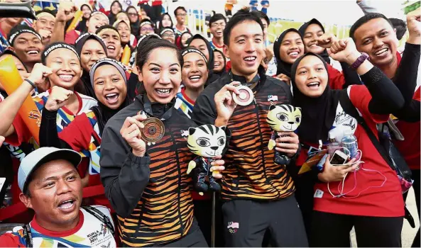  ??  ?? Dominating form: Malaysia’s Kevin Yeap and Heidi Gan showing off their gold medals after the men and women’s 10km open water race in Putrajaya yesterday.