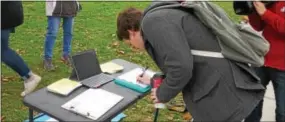  ??  ?? A West Chester University student signs a petition Tuesday calling on Congress to preserve DACA and protect the Dreamers.