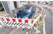  ?? FOTO: REICHWEIN / DPA ?? Nachbarn legten am Morgen nach dem Brand Blumen vor dem Haus nieder. Auch die Zeugen eines Unglücks benötigen oftmals Hilfe, um das Erlebte zu verarbeite­n.