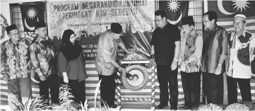  ??  ?? Azman strikes the gong to mark the launch of K1M Sebezau ‘Negaraku@Community’ programme, as Ali (fourth right) and others look on.