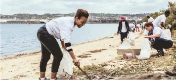  ?? MARISKA VAN DEN BRINK ?? AN EMPLOYEE from Dow helps with the clean-up at the Bayhead mangroves. |