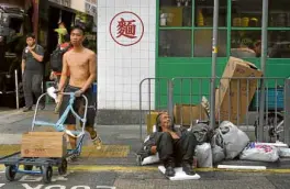  ?? —AP ?? HARD TIMES A homeless man sleeps on a street in Hong Kong as business plunged in the city’s shopping districts following more than four months of protests.