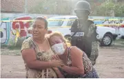  ?? REUTERS ?? Women outside a drug rehabilita­tion facility where assailants killed 24 people, according to Guanajuato state police.