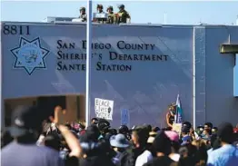  ?? K.C. ALFRED U-T ?? Black Lives Matter supporters hold a rally at the San Diego County Sheriff ’s Department’s Santee Station as deputies stand on the roof on June 7, 2020.