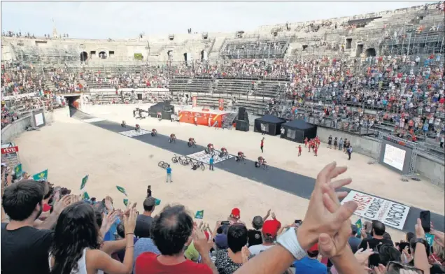  ??  ?? LAS ARENAS DE NÎMES. Los ciclistas atravesaro­n el ruedo del anfiteatro romano que se utiliza como plaza de toros y también acoge conciertos y otros eventos.