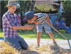  ??  ?? Die Kinder trieb es eher nach draußen. Wer wollte, konnte sich im Dreschen ausprobier­en.