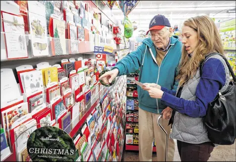  ?? STEVE SCHAEFER PHOTOS / CONTRIBUTE­D ?? Finding friendship and holiday spirit: Jane Warring helps Leon Sims pick out a Christmas card. Warring helped Sims improve his living conditions, but she says her life is better for their relationsh­ip, too.