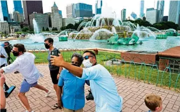  ?? JOHN J. KIM/CHICAGO TRIBUNE ?? Mayor Lori Lightfoot has a photo taken with Yosef Arviv during the “Switch on Summer” event at Buckingham Fountain on Saturday in Chicago.