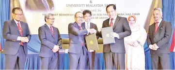  ??  ?? Raymond (centre) and Rosnah (second right) witness the exchange of signed documents between Dr Roslan (third left) and Dr Kamarudin (third right) at the BEM Roadshow 2017 yesterday.