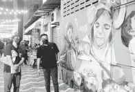  ?? — Gambar Bernama ?? MENARIK: Mohd Sharkar (dua kiri) tertarik dengan salah satu lukisan mural yang menghiasi dinding bangunan semasa melakukan tinjauan di Kuantan Art Street, Kuantan malam kelmarin. Lorong belakang barisan kedai lama di antara Jalan Besar dan Jalan Mahkota yang sebelum ini kelam dan suram kini bertukar lebih ceria dengan hiasan lukisan mural memaparkan kisah rakyat dan identiti negeri selain dihiasi lampu bagi menghidupk­an suasana waktu malam seterusnya menjadi tempat tarikan baharu Bandaraya Kuantan.