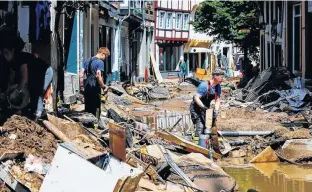  ?? THILO SCHMUELGEN • REUTERS ?? Firefighte­rs work on July 18 in an area affected by floods caused by heavy rainfall in the centre of Bad Muensterei­fel, Germany.