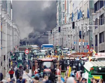  ?? — AFP ?? Smoke rises as farmers demonstrat­e outside the EU headquarte­rs during EU agricultur­e ministers meeting in Brussels.