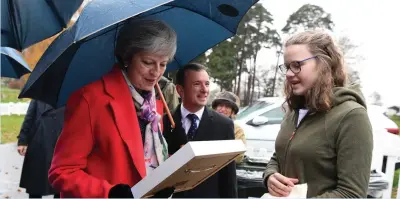  ?? (Rebecca Naden/Reuters) ?? BRITAIN’S PRIME MINISTER Theresa May receives a gift while touring at the Royal Welsh Winter Fair in Builth Wells yesterday.