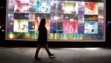  ?? REUTERS ?? A PEDESTRIAN walks past holiday window decoration­s outside of Bloomingda­le’s department store in New York.