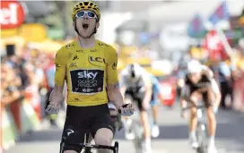  ??  ?? Britain’s Geraint Thomas, wearing the overall leader’s yellow jersey, celebrates as he crosses the finish line to win the 12th stage of the 105th edition of the Tour de France, between BourgSaint-Maurice-Les Arcs and Alpe d’Huez yesterday. — AFP