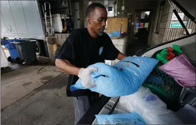  ?? AP/STEVEN SENNE ?? Dock worker Damon Jones places bags of ice into the trunk of a customer’s car Sunday at Brookline Ice Co. in Brookline, Mass.