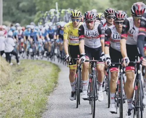  ??  ?? 0 Race leader Tadej Pogacar, wearing the yellow jersey, rides in the pack behind his Team UAE Emirates team-mates during Stage 16