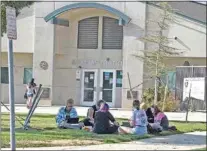  ?? NICK SMIRNOFF / FOR TEHACHAPI NEWS ?? These students found a suitable hot spot along with shade just outside the school administra­tion building Thursday morning during the Chromebook Sit-in demonstrat­ion at THS.