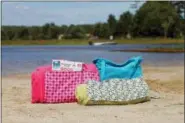  ?? HOLLY RAMER — THE ASSOCIATED PRESS ?? Beach towels can pull double duty or at least be easier to carry if you add straps to turn them into tote bags.