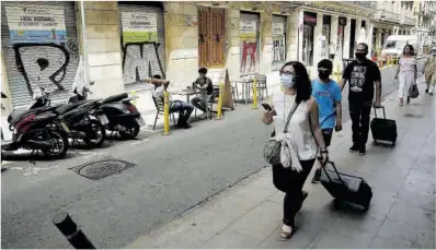  ?? Ricard Cugat ?? Una familia de turistas desfila frente a locales cerrados, en la calle de la Princesa.