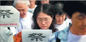  ?? YANG BO / CHINA NEWS SERVICE ?? Members of a Japanese delegation mourn outside the Memorial Hall of the Victims in Nanjing Massacre by Japanese Invaders in Nanjing on Tuesday.