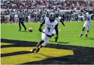  ?? (Pine Bluff Commercial/I.C. Murrell) ?? UAPB linebacker Kolby Watts (4) returns a fumble recovery 33 yards as defensive backs Paul Reeves and Chris Newton (36) celebrate in the second quarter of the SWAC championsh­ip Saturday.