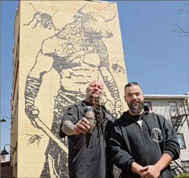  ?? Lori Van Buren / Times Union ?? Owner William Yager, left, and Manager Dan Dineen stand outside Albany’s Bull and Bee tasting room, which offers alcoholic drinks including mead. Its exterior boasts a giant mural of a Minotaur and bees.