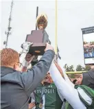  ?? ?? Muskogee receives the championsh­ip trophy after defeating Stillwater during the OSSAA 6A-II State Football Championsh­ip Game at UCO in Edmond.