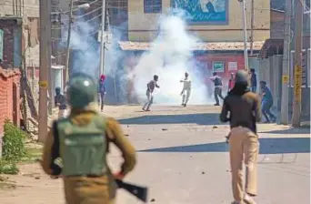  ?? AP ?? ■ Protesters, engulfed in tear gas smoke, clash with Indian paramilita­ry soldiers during a protest against the killing of rebels in Srinagar yesterday.