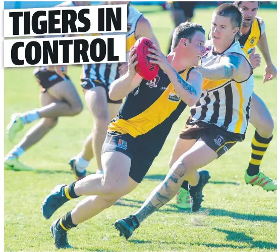  ?? GUTSY: Hermit Park Tigers’ Josh Andrews looks to evade the University Hawks defence. Picture: SCOTT RADFORD- CHISHOLM ??