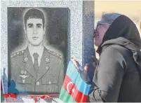  ?? (Aziz Karimov/Reuters) ?? A WOMAN grieves at a cemetery during a commemorat­ion for an Azeri service member killed during the battle over the Nagorno-Karabakh region last week in Baku.