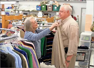  ?? Photos by Doug Walker, Rome News-Tribune ?? ABOVE: Evelyn Self puts a shirt up against her husband Andrew Self in the Hospitalit­y House Thrift Store on Friday. The store celebrated Customer Appreciati­on Day Friday after topping the $2 million sales mark over the past eight years.
LEFT: Inez...