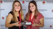  ?? Photo courtesy of American Red Cross ?? Maci and Cambria Lawrence hold up their Keep the Pressure kit during an American Red Cross recognitio­n ceremony.