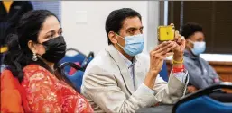  ?? ?? Vinayak Menon’s parents, Aswathy Gangadhara­n (left) and Ravi Menon, take video of his speech during the Voices for Prevention Substance Abuse Prevention Day at the Georgia State Capitol in Atlanta.