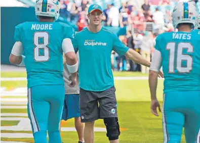  ?? JIM RASSOL/SUN SENTINEL ?? Miami Dolphins quarterbac­k Ryan Tannehill, center, on Sunday before the New England game, was walking without a limp Monday. Coach Adam Gase faces a crucial decision this week concerning the No. 1 QB’s status.