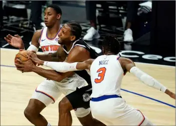  ?? AP Photo/Marcio Jose Sanchez ?? Los Angeles Clippers forward Kawhi Leonard, center, is defended by New York Knicks guard RJ Barrett (left) and center Nerlens Noel (3) during the first half of an NBA basketball game on Sunday in Los Angeles.