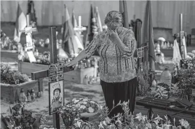  ?? Emilio Morenatti/Associated Press ?? A woman named Hanna, 62, cries at the grave or her son Shufryn Andriy, 41, a Ukrainian serviceman who died in the war against Russia, on Saturday at a cemetery in Lviv.