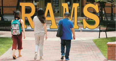  ?? STEVE HELBER/AP 2019 ?? Students walk around a RAMS sign at Virginia Commonweal­th University in Richmond. Proposed courses at VCU are among those under review by the Youngkin administra­tion.
