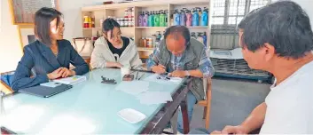  ?? ?? Young people are watching Lu Yongqing (second from right), head of the Songjiang Printmakin­g Academy, as he paints.